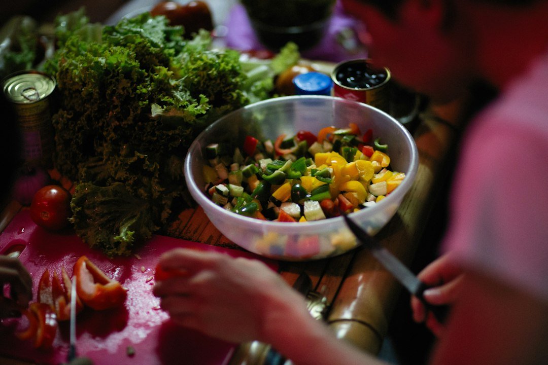 a person cutting up vegetables on a cutting board