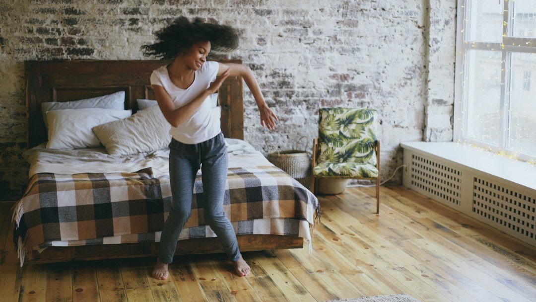 Young woman dancing in a bedroom